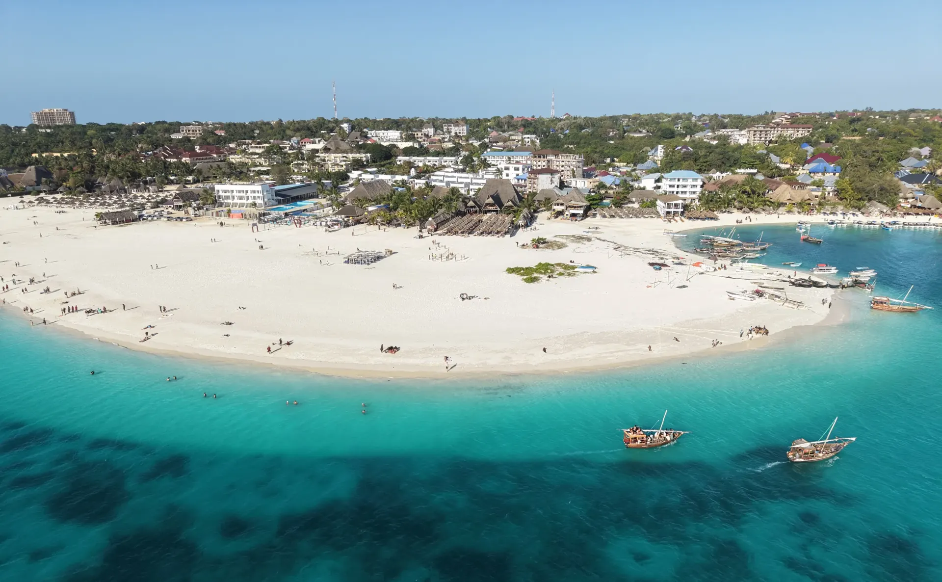 Aerial view of Nungwi beach in Zanzibar with traditional dhows on turquoise water